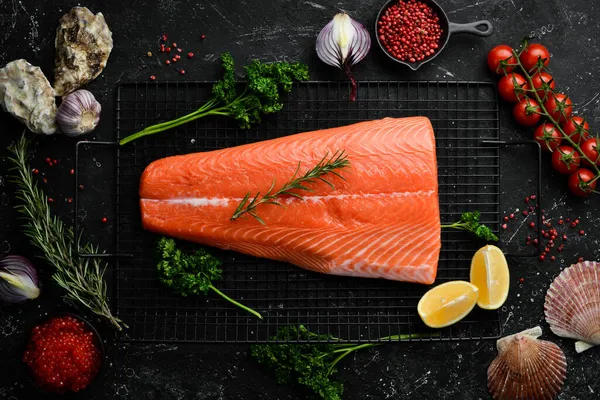 Biberiye ve baharatlı somon filetosu. Karanlık bir arka planda. Üst görünüm.