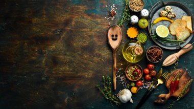 Sebze ve baharatlı siyah taş bir masanın üzerindeki çatal bıçak takımı. Yemek arkaplanı. Üst Manzara. Kırsal biçim.
