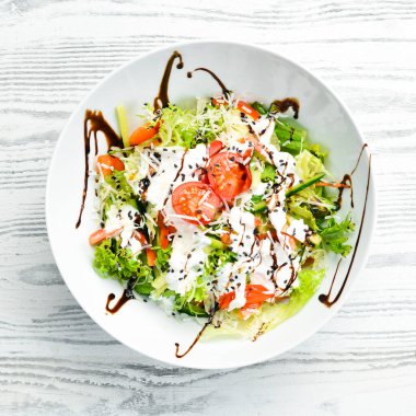 Sebze salatası: marul, domates, salatalık ve krema sosu. Sezar. Üst Manzara. Üst Manzara. Kırsal biçim.