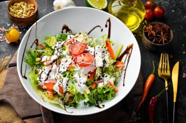 Sebze salatası: marul, domates, salatalık ve krema sosu. Sezar. Üst Manzara. Üst Manzara. Kırsal biçim.