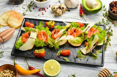 Siyah tabakta somon, marul ve parmesan peyniri. Üst Manzara. Kırsal biçim.