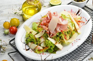 Prosciutto, peynir, armut ve otlu salata. Üst Manzara. Kırsal biçim.