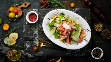 Prosciutto, peynir, armut ve otlu salata. Üst Manzara. Kırsal biçim.