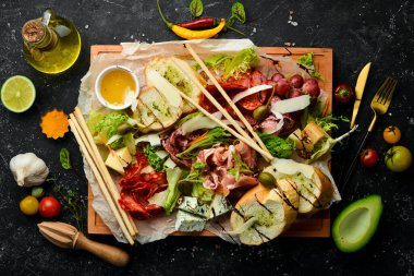 Antipasto. İtalyan yemeği. Prosciutto, kapari, salam, parmesan, tahtada bal. Üst Manzara. Kırsal biçim.