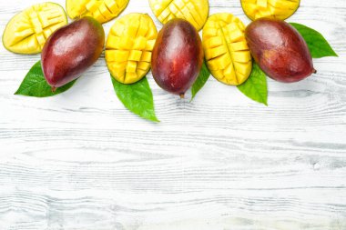 Mango geçmişi. Beyaz ahşap arka planda taze mango meyveleri. Üst Manzara. Tropik meyveler.