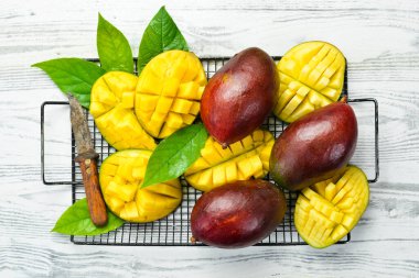 Beyaz ahşap bir arka planda tatlı mango dilimleri. Kırsal tarzda. Üst Manzara. Tropik meyveler.