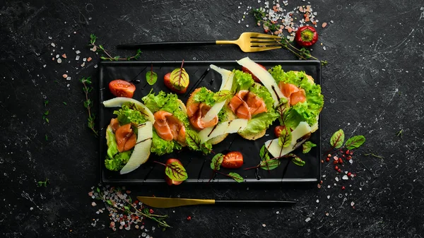 Bruschetta Con Salmón Lechuga Queso Parmesano Plato Negro Vista Superior —  Fotos de Stock