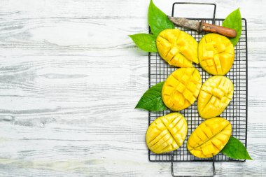 Beyaz ahşap bir arka planda tatlı mango dilimleri. Kırsal tarzda. Üst Manzara. Tropik meyveler.