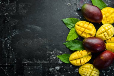 Eski ahşap arka planda yaprakları olan taze, tatlı mango. Kırsal tarzda. Üst Manzara. Tropik meyveler.