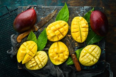 Eski ahşap arka planda yaprakları olan taze, tatlı mango. Kırsal tarzda. Üst Manzara. Tropik meyveler.