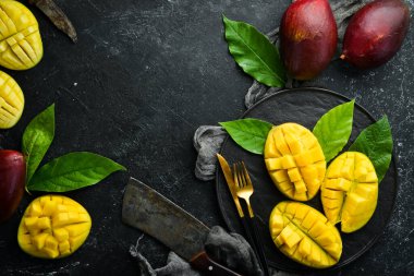 Eski ahşap arka planda yaprakları olan taze, tatlı mango. Kırsal tarzda. Üst Manzara. Tropik meyveler.