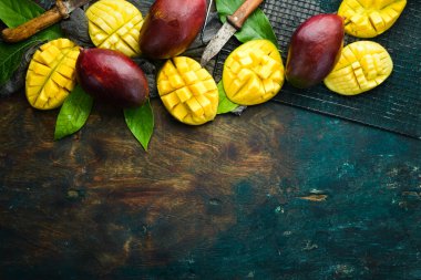 Eski ahşap arka planda yaprakları olan taze, tatlı mango. Kırsal tarzda. Üst Manzara. Tropik meyveler.