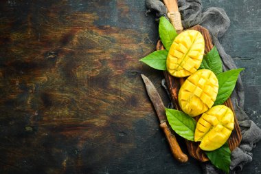 Eski ahşap arka planda yaprakları olan taze, tatlı mango. Kırsal tarzda. Üst Manzara. Tropik meyveler.