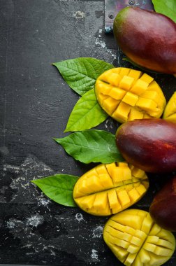 Eski ahşap arka planda yaprakları olan taze, tatlı mango. Kırsal tarzda. Üst Manzara. Tropik meyveler.