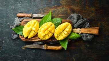 Eski ahşap arka planda yaprakları olan taze, tatlı mango. Kırsal tarzda. Üst Manzara. Tropik meyveler.