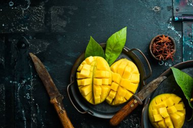 Eski ahşap arka planda yaprakları olan taze, tatlı mango. Kırsal tarzda. Üst Manzara. Tropik meyveler.