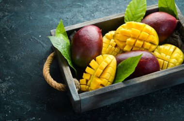 Mango ahşap bir kutuya konmuş. Tropik meyveler. Kopyalama alanı olan üst görünüm.
