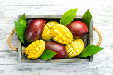 Mango ahşap bir kutuya konmuş. Tropik meyveler. Kopyalama alanı olan üst görünüm.