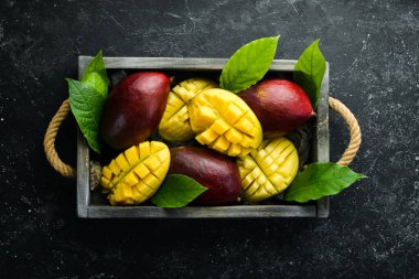 Mango ahşap bir kutuya konmuş. Tropik meyveler. Kopyalama alanı olan üst görünüm.