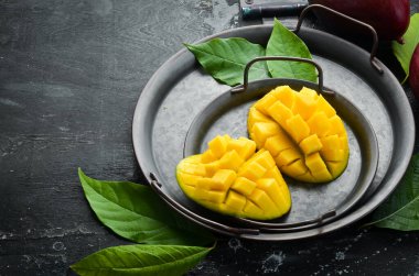 Mango. Taze sulu olgun mango tabakta dilimlere bölünmüş. Tropik meyveler. Kopyalama alanı olan üst görünüm.