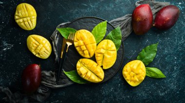 Mango. Taze sulu olgun mango tabakta dilimlere bölünmüş. Tropik meyveler. Kopyalama alanı olan üst görünüm.