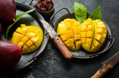Mango. Taze sulu olgun mango tabakta dilimlere bölünmüş. Tropik meyveler. Kopyalama alanı olan üst görünüm.