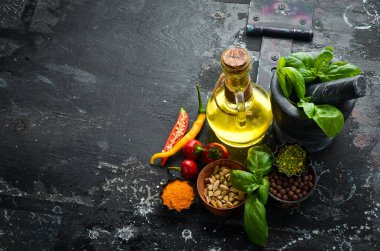 Eski, siyah bir arka planda bir dizi baharat. Fesleğen, yağ, biber ve baharat. Yemek arkaplanı. Üst görünüm.