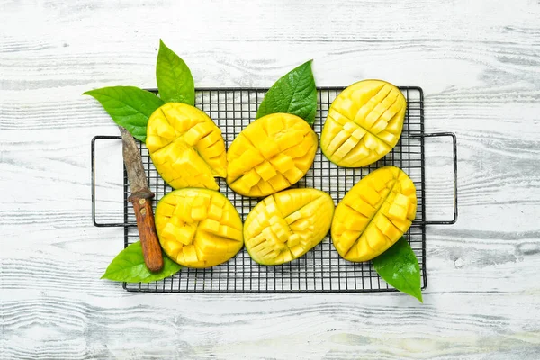Beyaz ahşap bir arka planda tatlı mango dilimleri. Kırsal tarzda. Üst Manzara. Tropik meyveler.
