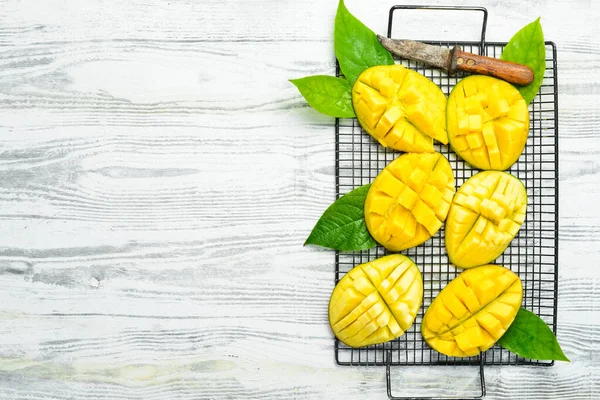 Beyaz ahşap bir arka planda tatlı mango dilimleri. Kırsal tarzda. Üst Manzara. Tropik meyveler.