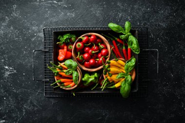 Siyah taştan bir arka planda koyu kırmızı biberlerin arka planı. Meksika mutfağı. Baharatlar. Üst görünüm.