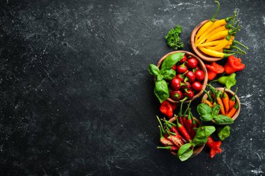 Siyah taştan bir arka planda koyu kırmızı biberlerin arka planı. Meksika mutfağı. Baharatlar. Üst görünüm.