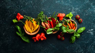 Siyah taştan bir arka planda koyu kırmızı biberlerin arka planı. Meksika mutfağı. Baharatlar. Üst görünüm.