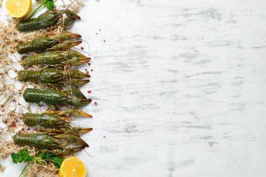 Beyaz bir mutfak masasında çiğ kerevit. Metnin için boş yer. Üst Manzara. Düz yatıyordu.