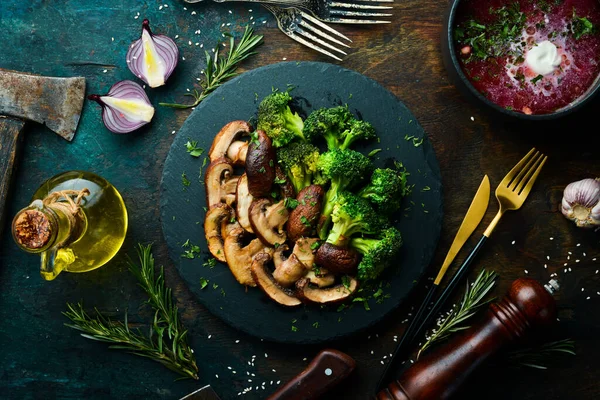 有机食品 在黑色的石板上煎蘑菇和西兰花 乡村风格 顶部视图 — 图库照片