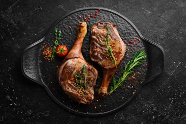 Baharatlı ve biberiyeli ördek budu. Barbekü eti. Üst Manzara. Siyah taş kesme masasının üstünde düz bir görünüm vardı..