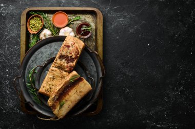 Tütsülenmiş domuz. Siyah taşlı arka planda baharat olan domuz yağı. Geleneksel Ukrayna yemekleri. Üst görünüm.