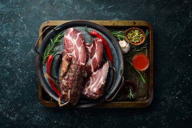 Kurutulmuş ve tuzlanmış et. Prosciutto, Jamon, siyah taşlı arka planda. Üst Manzara. Metin için boş alan.