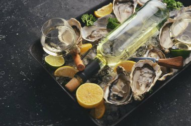 Karanlık bir mutfak masasında bir şişe yıllanmış şarap ve taze istiridye. Deniz ürünleri. Üst Manzara. Düz yatıyordu.