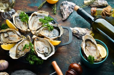 Karanlık bir mutfak masasında bir şişe yıllanmış şarap ve taze istiridye. Deniz ürünleri. Üst Manzara. Düz yatıyordu.