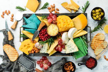 Tahta bir kutuda abur cubur ve peynir seti. Beyaz ahşap bir arka planda. Boş kopyalama alanı.