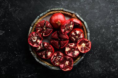 Yapraklı sağlıklı nar meyvesi ve tahta bir kutuda açık nar. Üst görünüm.