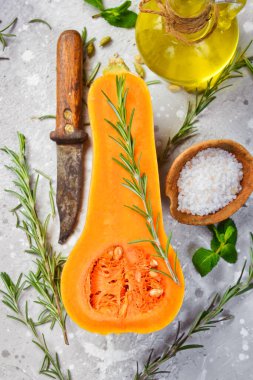 Balkabağı tabakları hazırlanıyor. Biberiye ve baharatlı taze balkabağı. Taş zeminde. Üst görünüm.