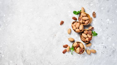 Taş bir arka planda kabuklu cevizler. Çeşit çeşit fındık. Üst görünüm.
