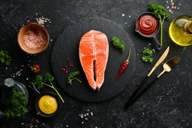 Çiğ somon bifteği. Siyah taşlı arka planda deniz ürünleri. Organik yiyecekler.