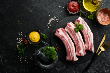 Domuz eti. Siyah taştan arka planda çiğ domuz pirzolası. Üst Manzara. Yemek pişirme.