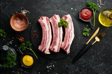 Domuz eti. Siyah taştan arka planda çiğ domuz pirzolası. Üst Manzara. Yemek pişirme.