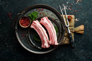 Domuz eti. Siyah taştan arka planda çiğ domuz pirzolası. Üst Manzara. Yemek pişirme.