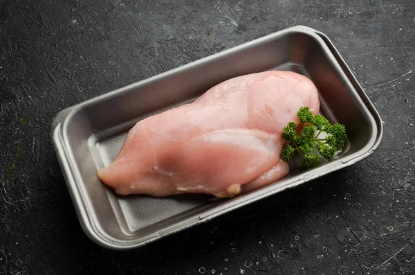 Chicken meat. Raw fresh chicken breast on black slate stone background. Top view. Raw meat.