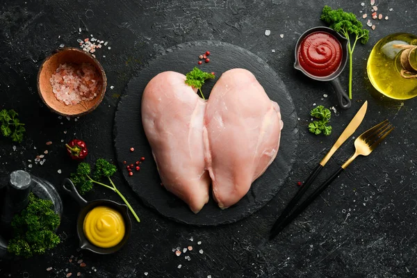 Chicken meat. Raw fresh chicken breast on black slate stone background. Top view. Raw meat.