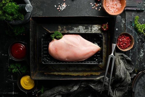 Chicken meat. Raw fresh chicken breast on black slate stone background. Top view. Raw meat.